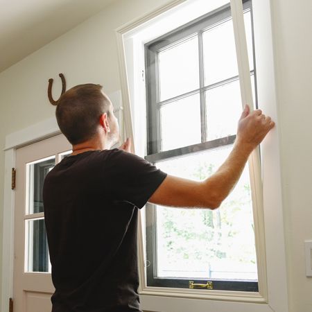 Man inserting his Indow Insert into window frame