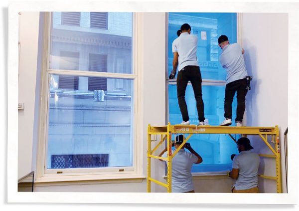 Indow inserts being installed in large commercial windows at 25 Broad Street in New York City.