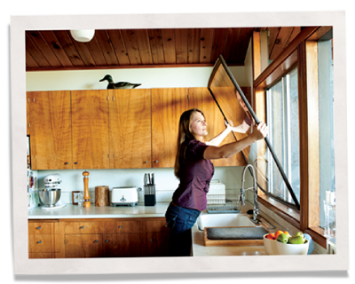 Woman installing Indow insert for the simple soundproofing in windows.