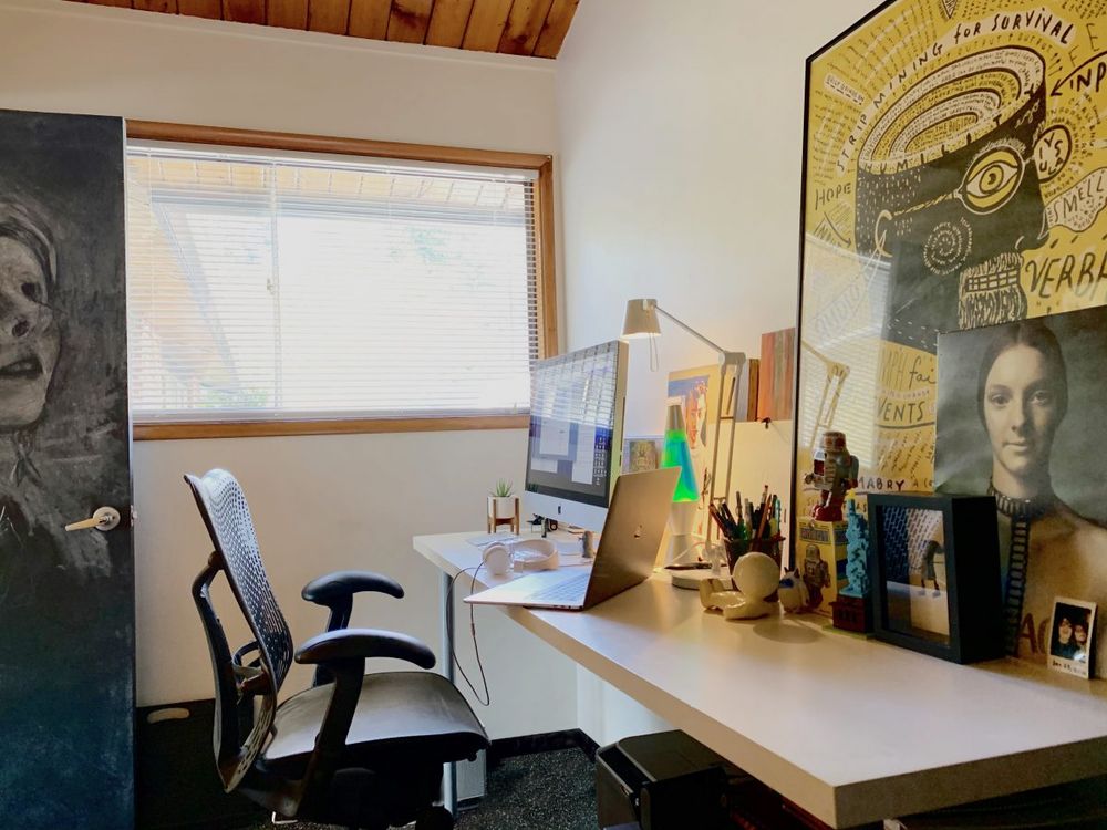 home office with door and large window with work space and various noise-absorbing decorations