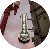 A view of a lit up hotel sign at dusk.