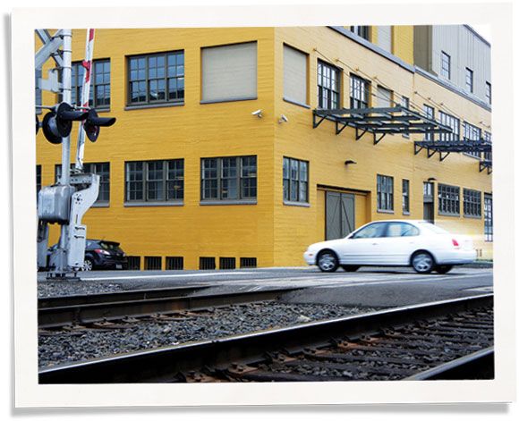train noise outside of yellow commercial building: commercial soundproofing via windows & walls.
