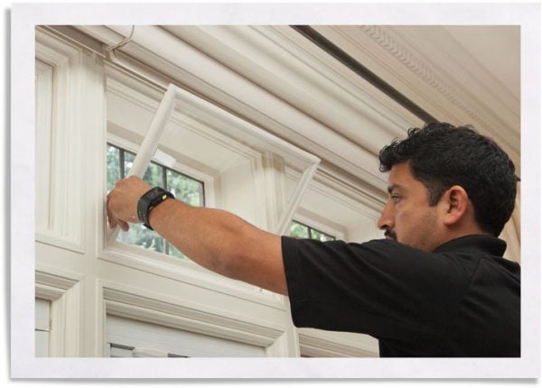 man installing custom window insert into window