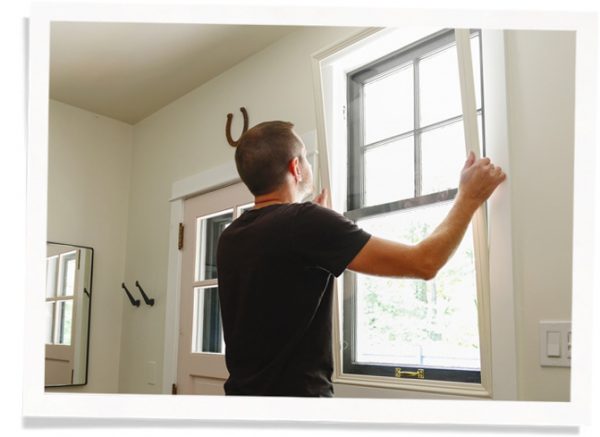 man installing window insert to block noise and drafts
