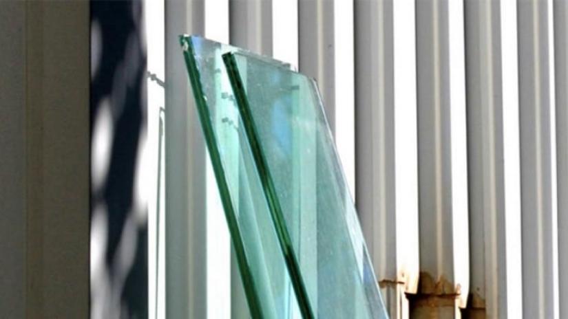 Two sheets of glass are leaning against a wall, an example of an insulated glass unit.