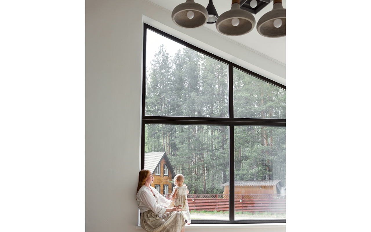 mother and child sitting near trapezoid window